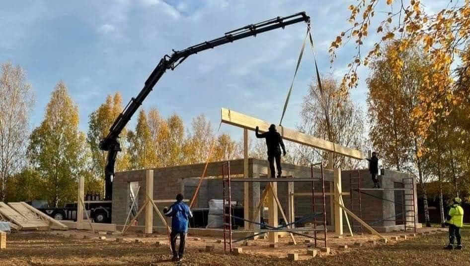 Kraana tõstab puittala ehitusjärgus hoone kohale